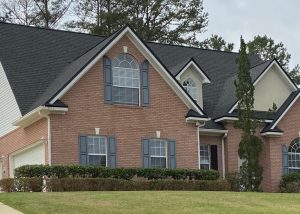 Roof replacement crew installing new shingles on a large residential home in Crawfordville, FL.