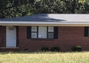 Roofers installing new asphalt shingle roof on residential home in Tallahassee.