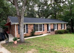 Roofers installing new roof on a brick residential home in Tallahassee.