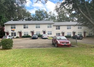 Roofers installing new roof on residential building in Tallahassee.