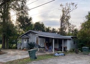 Roofers inspecting a residential roof for storm damage in Crawfordville, Florida.