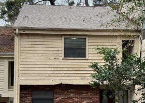 Roof repair crew inspecting a residential roof after storm damage.
