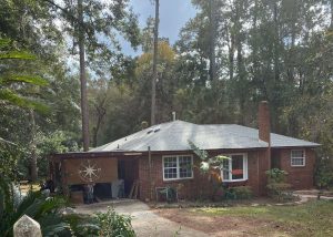 Roofers inspecting a residential roof with storm damage in Crawfordville, FL.