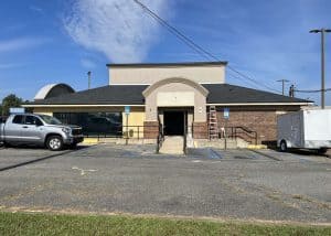 Roofers installing new roofing on a commercial building in Crawfordville, Florida.