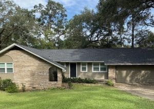 Roofers inspecting a residential roof for storm damage in Crawfordville, Florida.