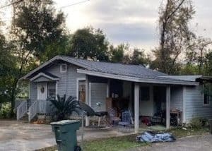 Roofers inspecting a residential roof for storm damage in Tallahassee, Florida.