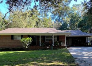 Roofers installing new asphalt shingle roof on residential home in Crawfordville, FL.