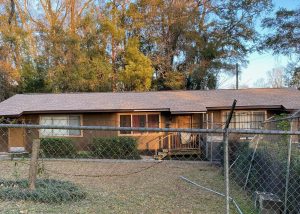 Roof replacement crew installing new shingles on a residential home in Crawfordville, FL.