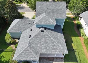 Aerial view of a residential roof replacement project in Crawfordville, Florida, showing new asphalt.