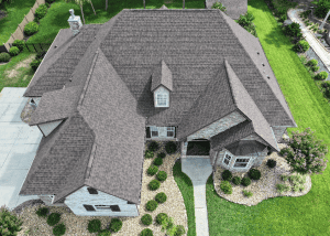 Roofers working on a residential home with a new asphalt shingle roof.