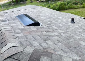 New asphalt shingle roof with skylight installation by Roofs by PRO.