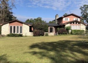 Roof installation on a large residential home with a mix of stone and shingle roofing materials.